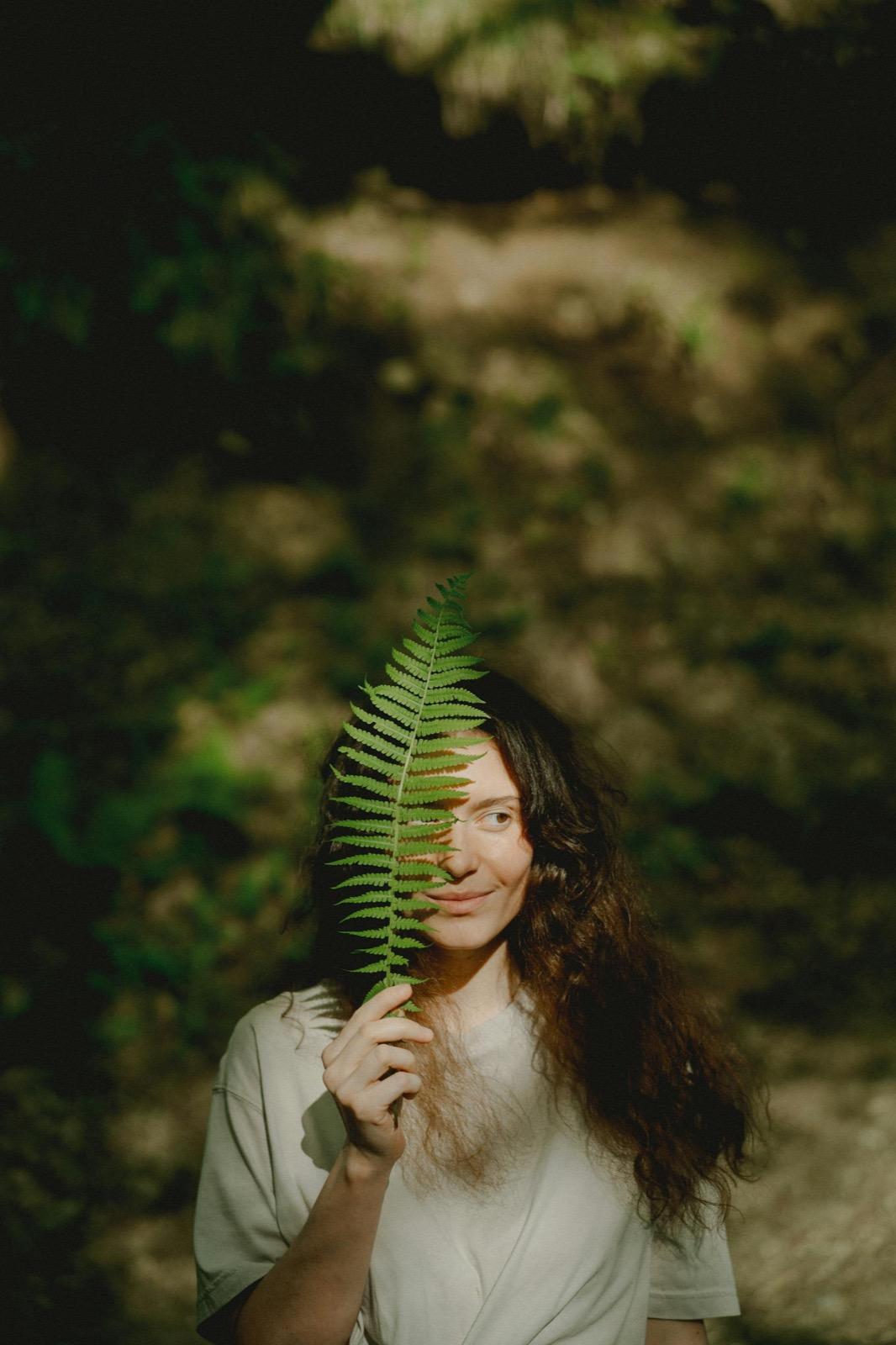 Woman holding a fern leaf